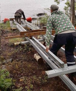 Två personer monterar en båtslip med hjälp av demonterings- alt monteringsverktyget