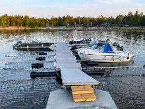 Bild på Outrigger™ båtbrygga som endast har en centrerad ponton under gångdelen som balanseras med hjälp av pontoner på båtbommarna