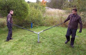 Två personer som använder SR100 för att skruva ner en skruvpåle