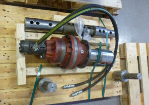 En hydraulisk rotator, färdig för transport, vilar på en träpall.