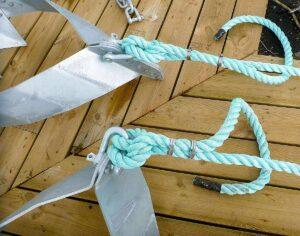 En robust Moorsafe ankare med en tjock, blå lina fastsatt, placerad på en träbrygga.