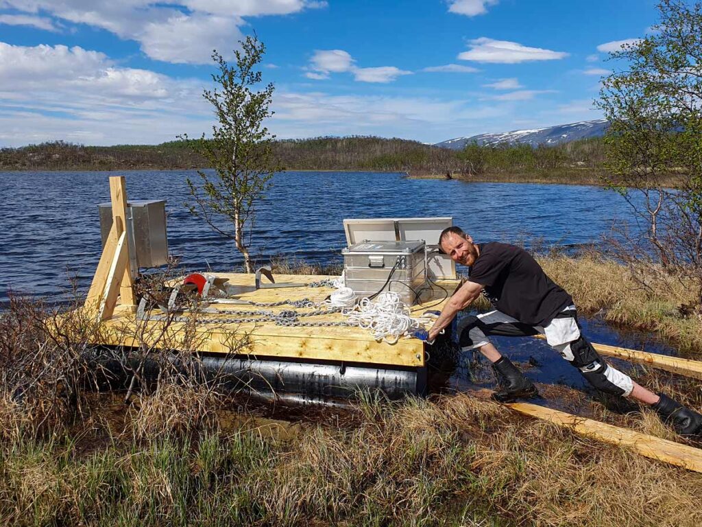 Forskningsplattform med HDPE-pontoner vid stranden i Abisko med sensorer och utrustning.