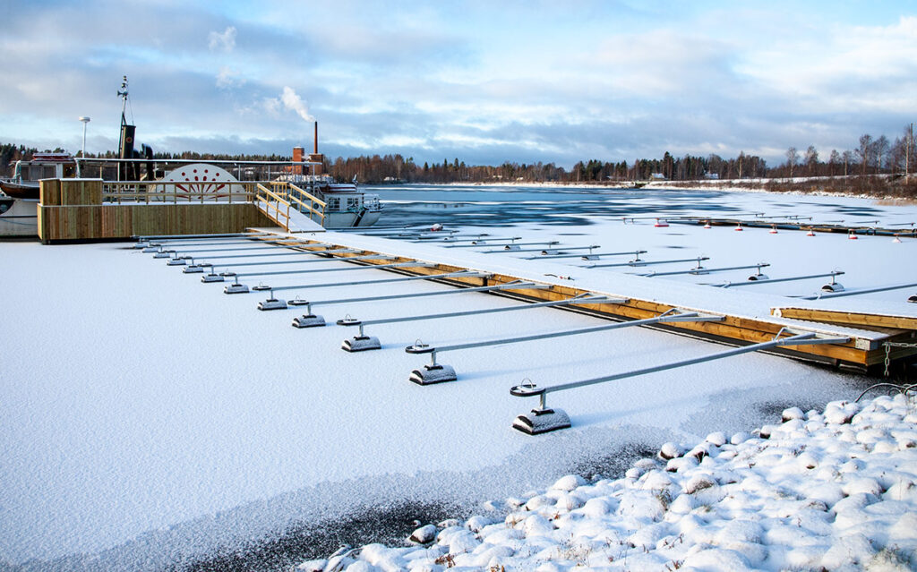Guide till att köpa flytbrygga som klarar is – AlfaBryggans rörpontonsystem i fastfruset tillstånd vid en båthamn.